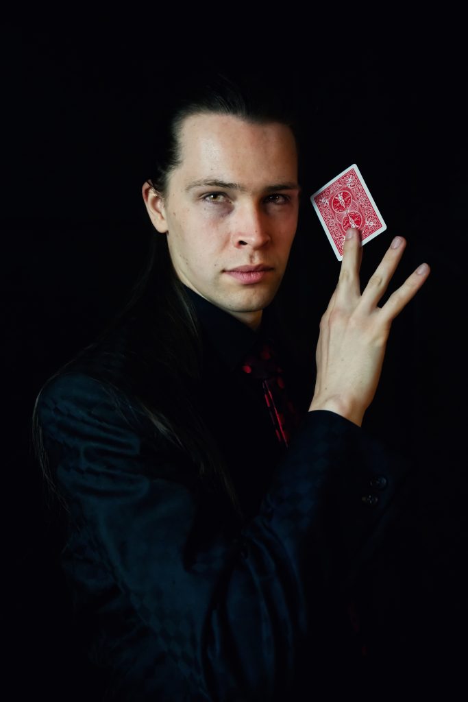 Convin Splettsen hälte ein rote Spielkarte neben sein Gesicht.